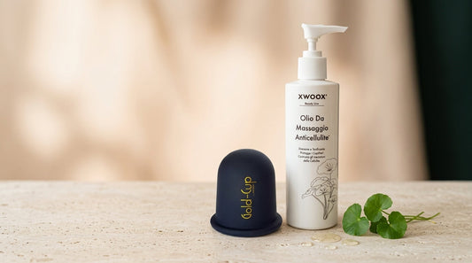 Coppetta in silicone Gold-Cup e olio anticellulite XWOOX disposti insieme, il kit per il rituale anticellulite completo